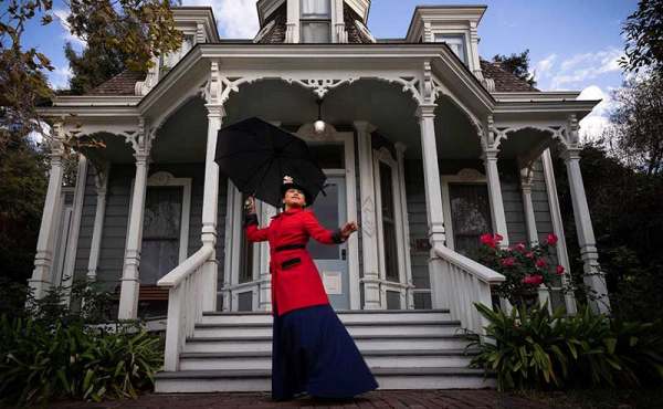a woman in period clothing holding an umbrella