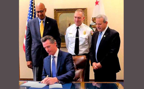a man at his desk surrounded by other men
