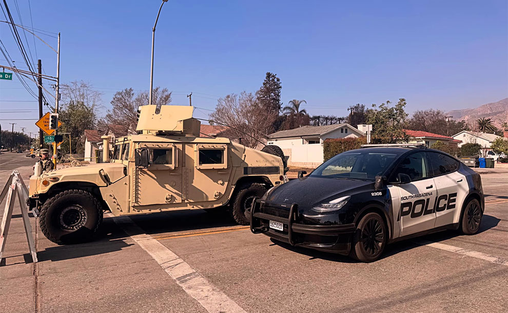a military vehicle next to a police car