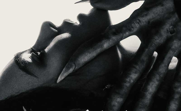 A hand with long nails over a woman's face