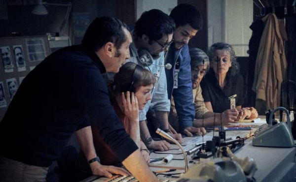 people gathering in a news room