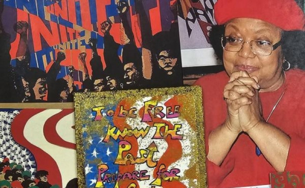 A woman smiling surrounded by art