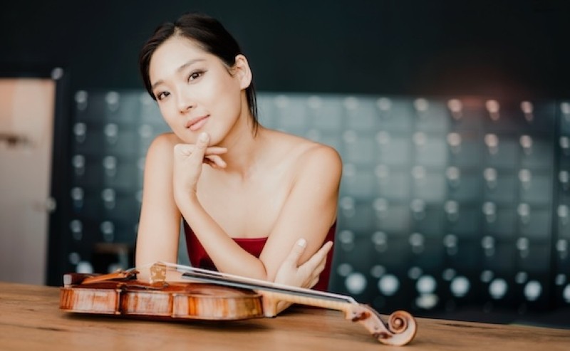 A woman smiling with a violin