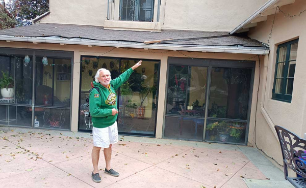 A man pointing to his roof