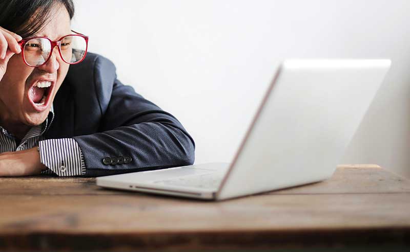 someone upset with reading something on his laptop