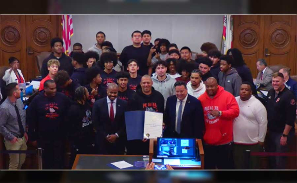 a group of high school football players, coach and politicians