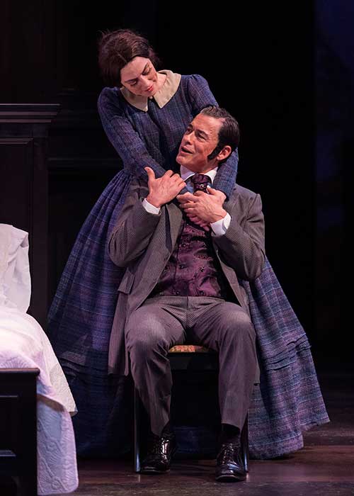 a woman hugging a man sitting