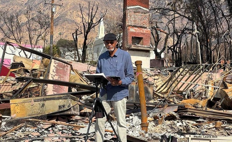 A man sketching in front of rubble