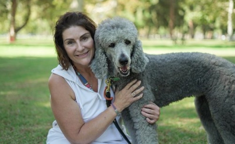 A woman smiling with a service dog