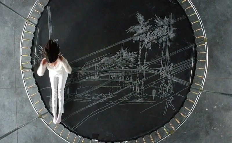 A woman on a trampoline marked with chalk drawings