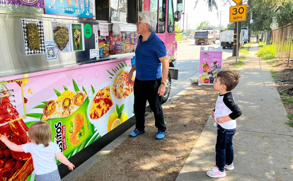 a man with kids by a truck
