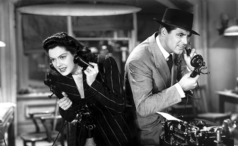 A black and white photo of a man and a woman on telephones