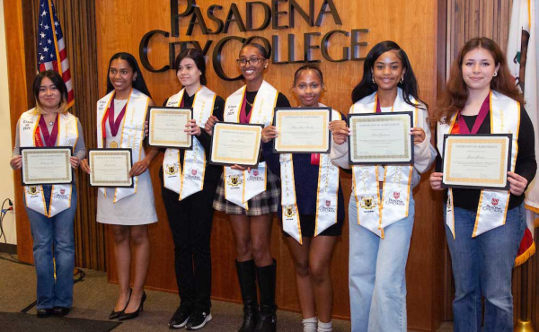 graduates holding diplomas