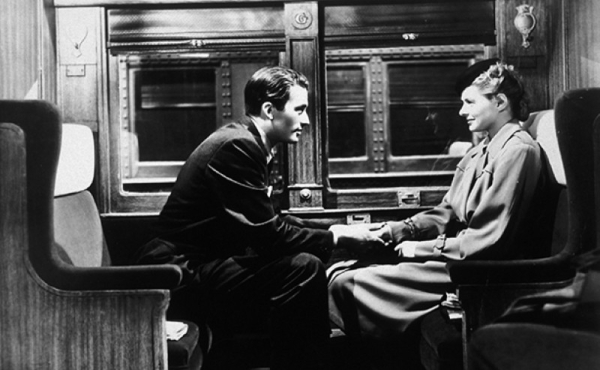 A black and white photo of a man holding a woman's hand