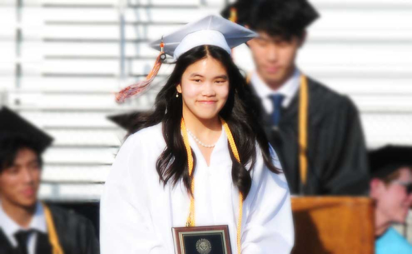 a girl in white graduation gown and cap