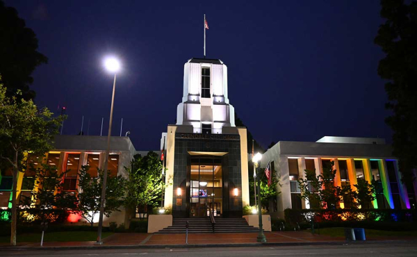 a lit city hall with rainbow colors