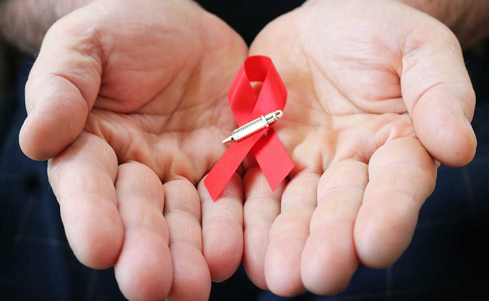 two hands holding a red ribbon