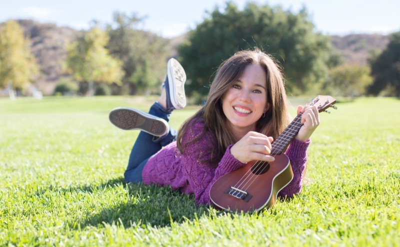 A woman smiling with a ukulele