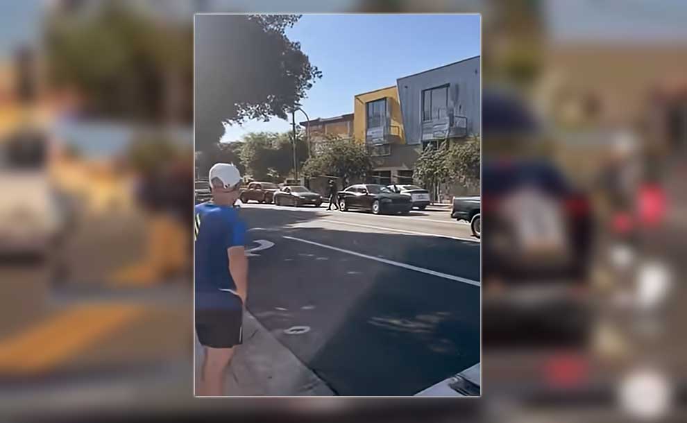 a man holding gun inn the street
