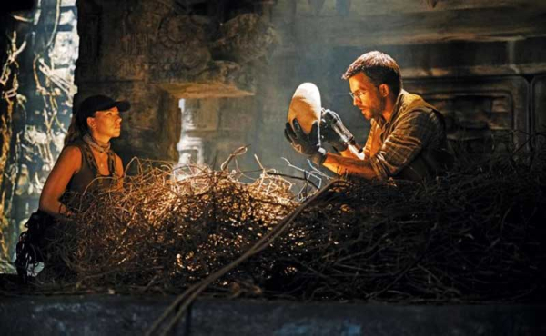 a man and a woman inspecting a large egg