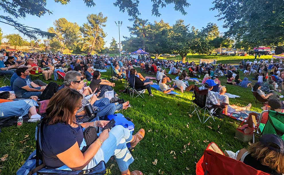 people sitting on lawn chairs in a park