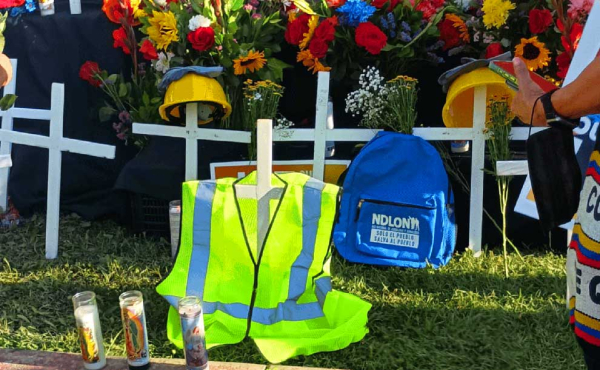 vest, a backpack and flowers at a vigil