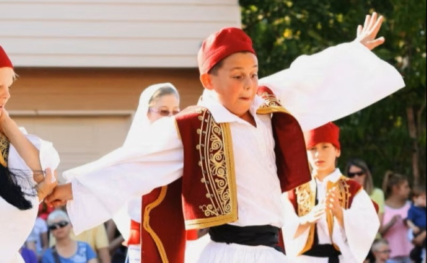 A boy dancing in traditional Greek clothing