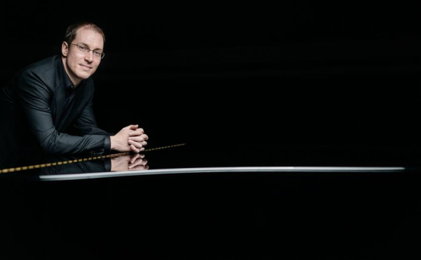 Musician next to piano.