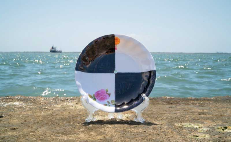 Art of a large, decorative plate at the beach
