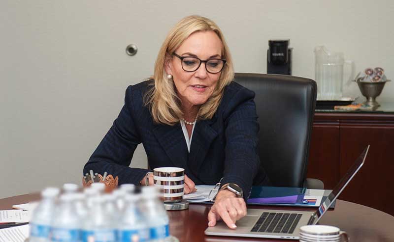 a woman pointing at a laptop