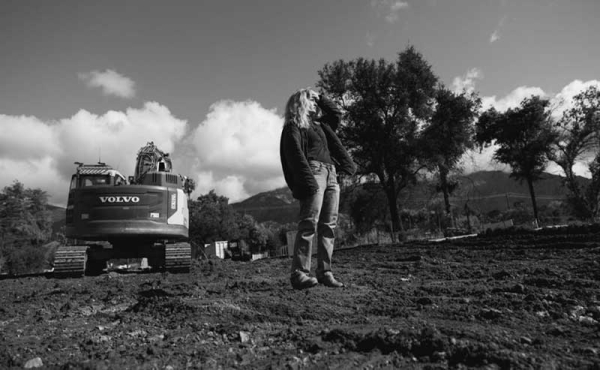 a woman standing on an empty lot that burned