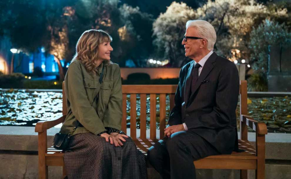 a man and a woman sitting by a bench