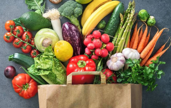 paper grocery bag full of colorful vegetables and fruit