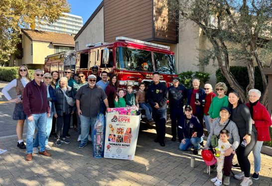 Firefighters and public members pose in front of an engine