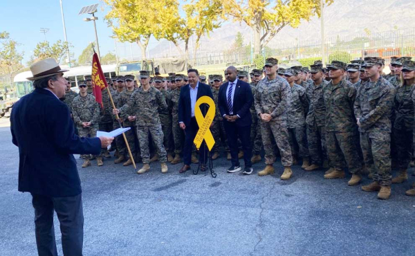 a man speaking to servicemen