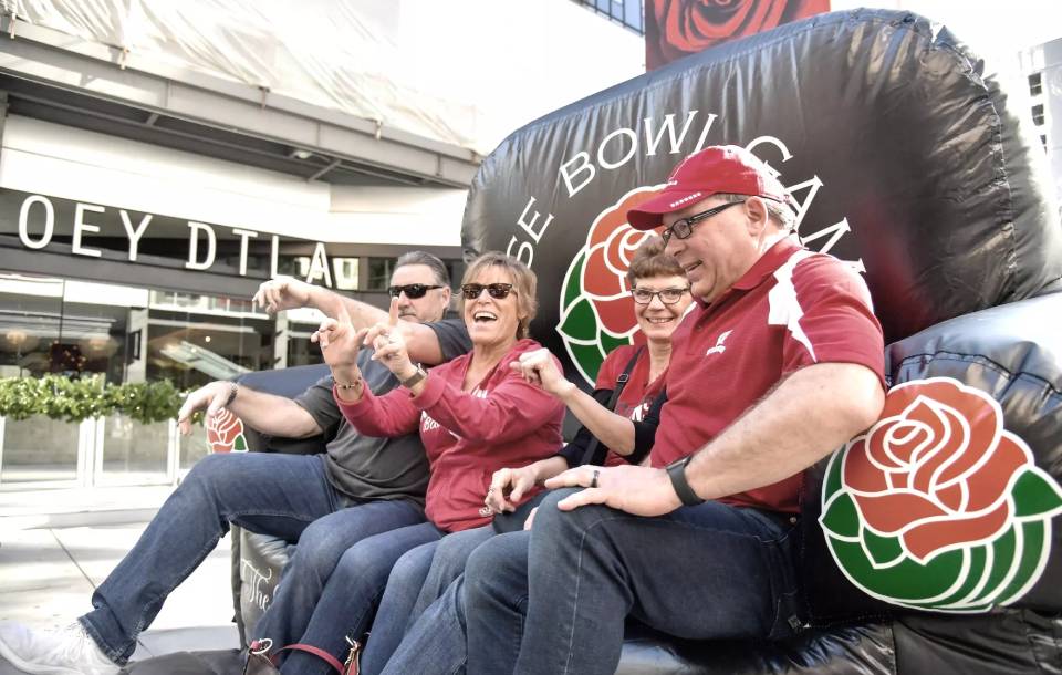 family laughs atop a black Rose Bowl inflated throne