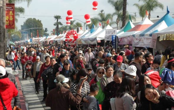 large crowd in aisle between two rows of white tents