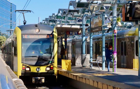 LA Metro station with yellow train docked and destination sign reading Santa Monica