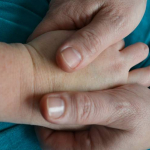 one hand stroking another hand