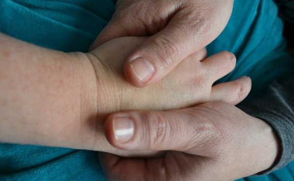 one hand stroking another hand