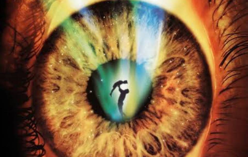 enlarged eyeball with golden flecks like sun with silhouette of adult holding child into the sky inside the iris