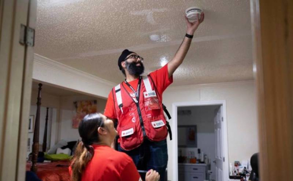 a volunteer installing a fire alarm