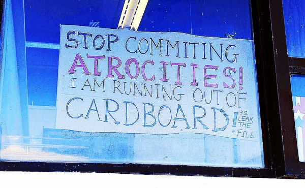 A sign that says: "Stop committing atrocities, I am running out of cardboard"